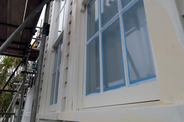 Villa wooden windows with blue tape and filler