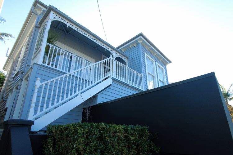 Villa with dark plaster garage and white windows and handrails