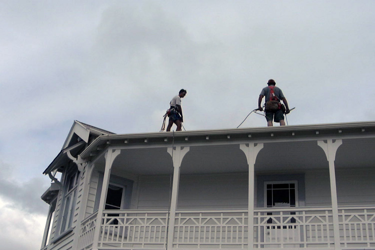 2 people on an iron roof with harness