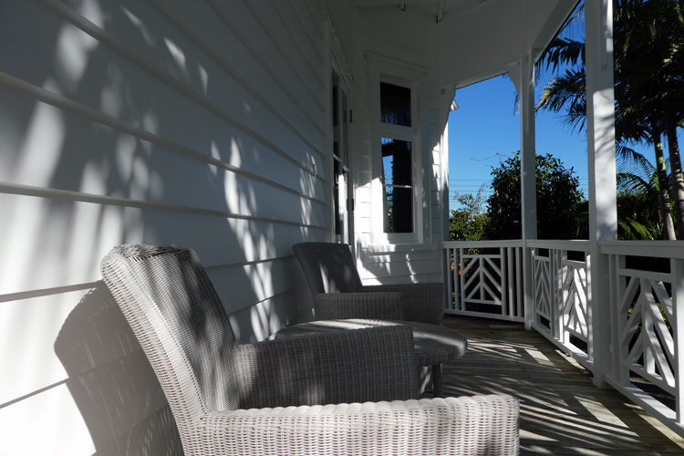 a chair on a balcony with white weatherboards