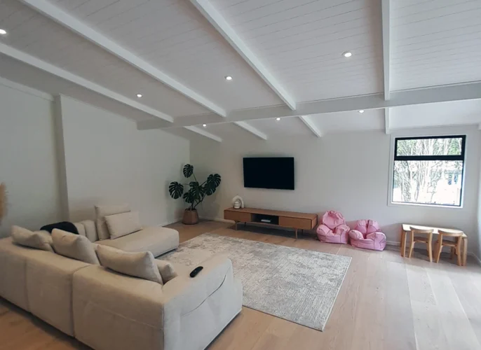 A cozy lounge with a couch, TV, and chair in a well-furnished living room.